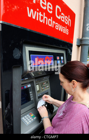 Femmina utilizzando il collegamento bancomat con il prelievo gratuito di denaro contante matlock England Regno Unito Foto Stock