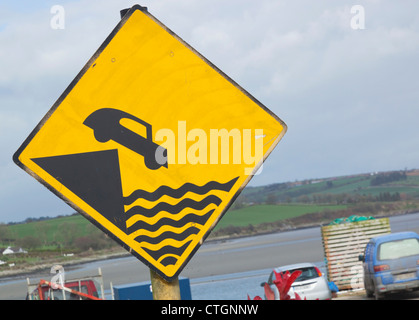 Courtmacsherry-Timoleague estuario, West Cork, Irlanda. Segnaletica di avvertimento pericolo di andare troppo vicino al bordo del molo. Foto Stock