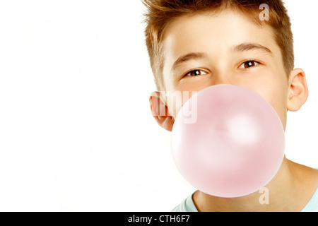 Ragazzo fare bolla con masticare su sfondo bianco Foto Stock