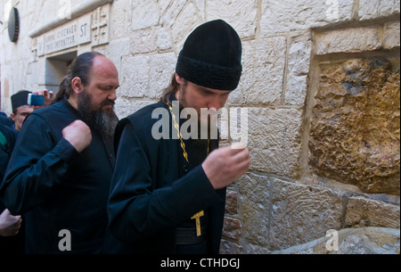 Pellegrino cristiano prega nella quinta stazione della Via Dolorosa durante il Venerdì Santo in Gerusalemme Israele Foto Stock