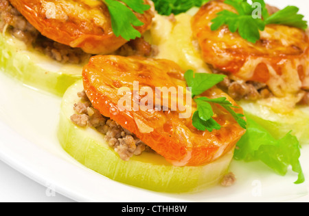 Backup di midollo di verdure ripiene di carne, pomodoro, formaggio e verdure su una piastra bianca Foto Stock