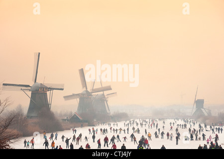 Dutch pattinatori di fronte a cinque dei 19 mulini a vento a Kinderdijk in Alblasserwaard polder, Holland, Paesi Bassi. Foto Stock