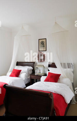 Rosso camera accentati con il mogano sleigh beds Foto Stock