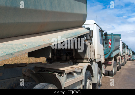 Fila di autocarri con cassone ribaltabile e attrezzatura per movimento terra a un'autostrada Sito in costruzione in Germania Foto Stock