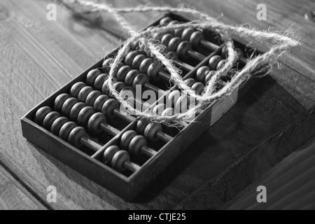 Un legno di antiquariato abacus. su una panca in legno, la fotografia in bianco e nero Foto Stock