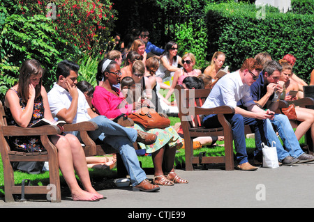 Londra, Inghilterra, Regno Unito. Le persone che si godono il sole durante la pausa pranzo in Victoria Embankment Gardens Foto Stock