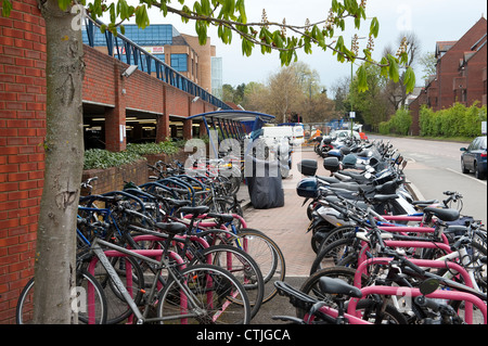 Motociclette e biciclette parcheggiate in modo sicuro in una area di parcheggio al di fuori di una stazione ferroviaria in Inghilterra. Foto Stock