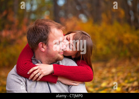 I giovani coniugi abbracciando intimamente in un parco in autunno; Edmonton Alberta Canada Foto Stock