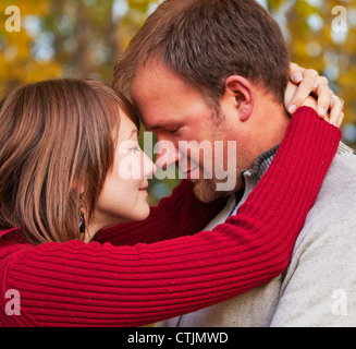 I giovani coniugi abbracciando intimamente in un parco in autunno; Edmonton Alberta Canada Foto Stock