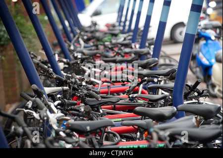 Le biciclette parcheggiate undercover saldamente in una area di parcheggio al di fuori di una stazione ferroviaria in Inghilterra. Foto Stock
