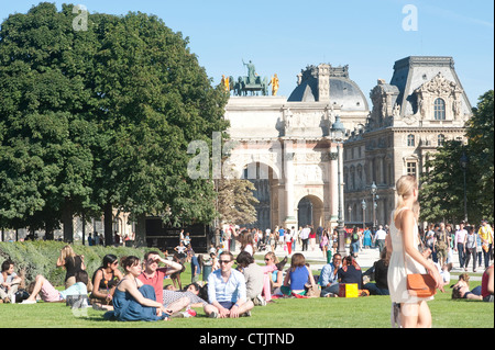 Parigi, Francia - Le persone che si godono una giornata di sole in giardino intorno al Louvre e Arc de triomphe du Carrousel Foto Stock