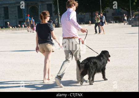 Parigi, Francia - una giovane coppia in possesso di un cane al guinzaglio Foto Stock