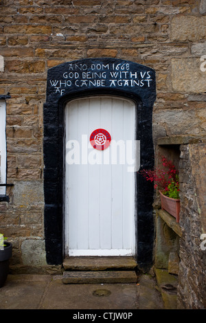 ' Romani 8:28-31 Old datata proprietà in Hawes, Wensleydale, North Yorkshire National Park, Regno Unito Foto Stock