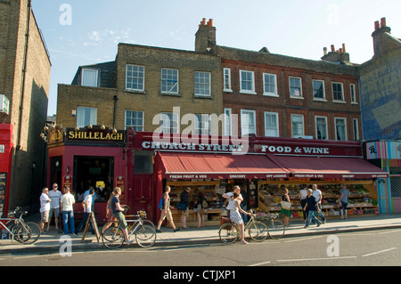 Persone su bycycles al di fuori del negozio a Stoke Newington Church Street, Hackney Londra Inghilterra REGNO UNITO Foto Stock
