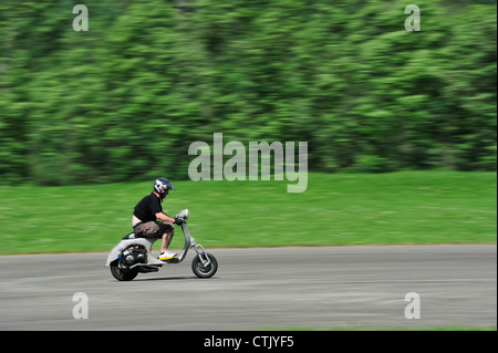 Scooter pilota. Sfocatura di movimento su ruote e lo sfondo Foto Stock