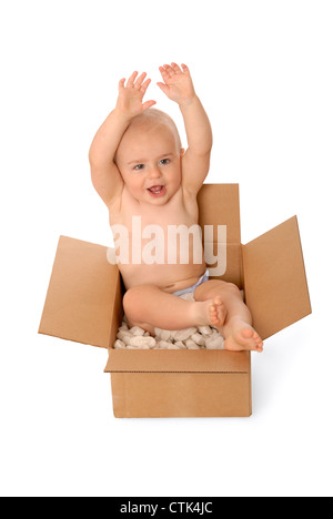 Felice anno vecchio bimbo seduto in una scatola di cartone con gommapiuma di arachidi. Foto Stock