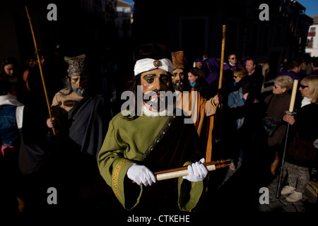 Un uomo mascherato vestito come un personaggio biblico contiene una pergamena durante una PASQUA SETTIMANA SANTA PROCESSIONE in Puente Genil, Spagna Foto Stock