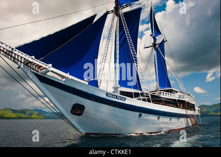 Un 108 piedi in legno tradizionali Phinisi schooner, 'l'Ombak Putih', qui a vela nel Parco Nazionale di Komodo in Indonesia orientale. Foto Stock