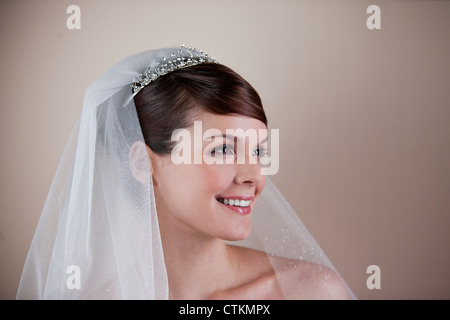 Una giovane sposa che indossa un diadema e velo, guardando al lato Foto Stock