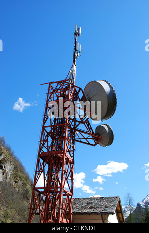 Comunicazione enorme torre per antenna e parabole satellitari contro il cielo blu Foto Stock