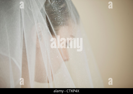 Una giovane sposa che indossa un diadema e velo, guardando verso il basso Foto Stock
