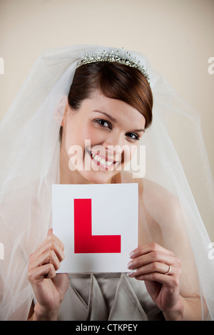 Una giovane sposa in possesso di un permesso di studente piastra, sorridente Foto Stock