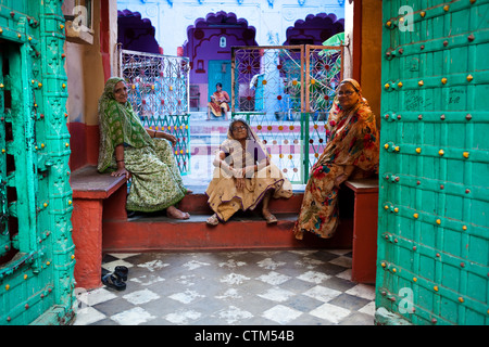 Le donne indiane seduti all'interno di casa colorati in Jodhpur, Rajasthan Foto Stock