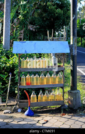 Bottiglie di benzina disponibile per la vendita su una bancarella per la strada. Nei pressi di Ubud, Bali, Indonesia Foto Stock