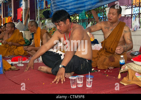 Maglietta rossa guardie ricevere 'Sak Yan' durante l'occupazione di Bangkok in primavera 2010 Foto Stock