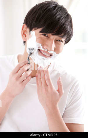 Giovane uomo che fa la rasatura Foto Stock