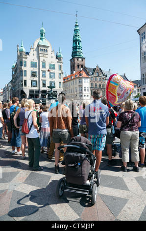 La folla di gente a guardare gli artisti di strada a Amagertorv per lo shopping, il divertimento e la via pedonale Strøget a Copenaghen. Foto Stock