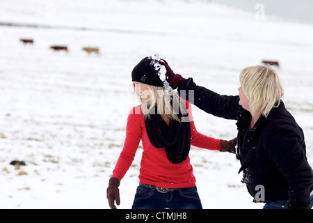 Due giovani donne avente una lotta con le palle di neve, Kamberg, KwaZulu-Natal, Sud Africa Foto Stock