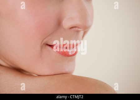 Una giovane donna sorridente, bocca chiusa, close-up Foto Stock