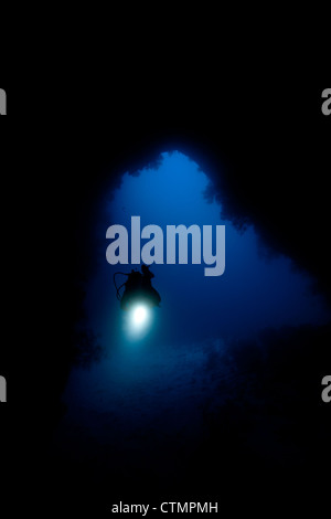 Scuba Diver esplorare Siaes Tunnel a più di 100 piedi nelle isole di Palau in Micronesia. Foto Stock