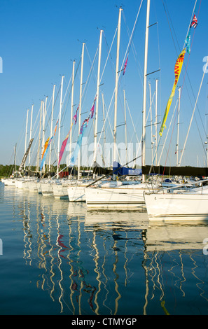 Yachts in Hamble Marina con piloni riflessi nell'acqua Foto Stock