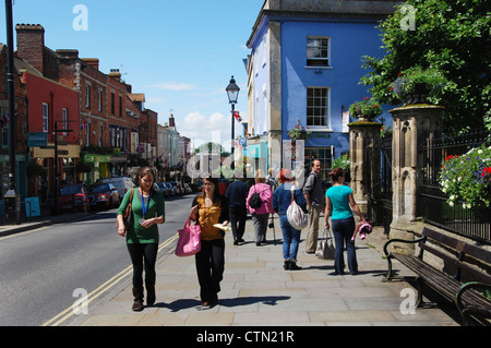 La gente colorata in Glastonbury High Street Somerset Inghilterra Foto Stock