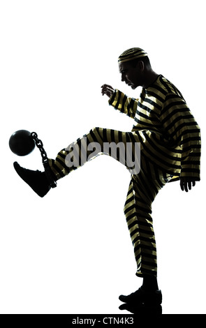 Un uomo caucasico prigioniero criminale che giocano a calcio con catena pallina in studio isolato su sfondo bianco Foto Stock