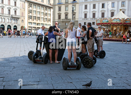 Gruppo di turisti su macchine Segway ascoltare la loro guida in Piazza Reppublica, Firenze, Italia Foto Stock