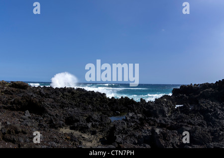 Spiaggia vulcanica vicino a South Point battuto da surf, Big Island delle Hawaii. Foto Stock