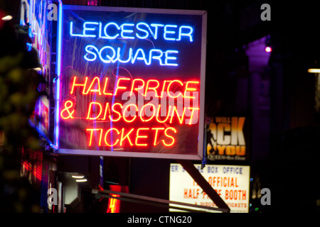 Leicester Square metà prezzo biglietti insegna al neon di notte con altre insegne illuminate in background Londra Inghilterra REGNO UNITO Foto Stock