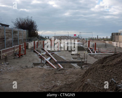 Basi per il nuovo edificio di fronte al mare che mostra le tubazioni di scarico e calcestruzzo Foto Stock