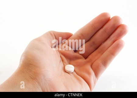 Donna di mano che tiene un medicinale bianco tablet nel palmare Palm. Foto Stock