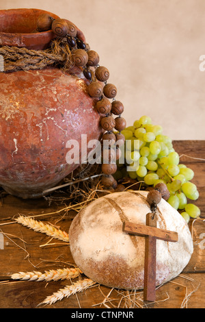 Antiquariato brocca vino, croce e rustico della pagnotta di pane come simboli cristiani della fede Foto Stock