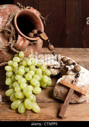 Antiquariato brocca vino, croce e rustico della pagnotta di pane come simboli cristiani della fede Foto Stock