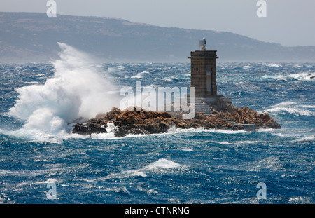 Le onde rompono su Lighthouse vicino a Isola di Rab in Croazia Foto Stock