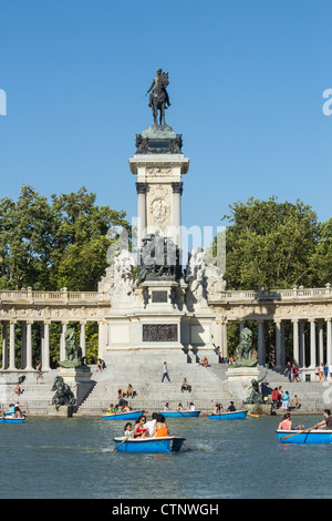 In barca il lago nel Parco del Retiro di Madrid in Spagna. Monumento al Re Alfonso X11 affacciato sul lago Foto Stock