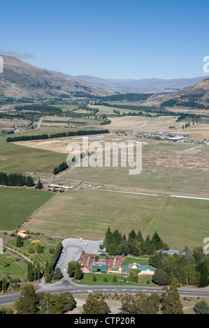 La vista ad est attraverso il Clutha vale da Mt Ferro, Wanaka, con il mondo di rompicapo attrazione turistica in primo piano Foto Stock