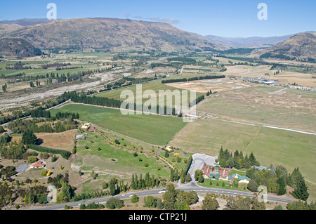 La vista ad est attraverso il Clutha vale da Mt Ferro, Wanaka, con il mondo di rompicapo attrazione turistica in primo piano Foto Stock