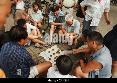 Un gruppo di uomini a giocare a scacchi cinesi sulla strada durante i giochi estivi Foto Stock