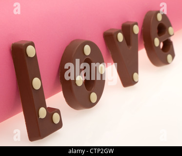 La parola "amore" digitato nel cioccolato al latte lettere - profondità di campo - studio shot Foto Stock